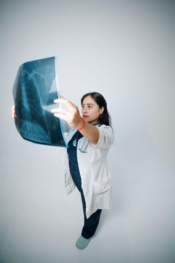 Female doctor analysing an X-ray with care, representing treatment available under Ayushman Bharat PM-JAY at empanelled hospitals in other states