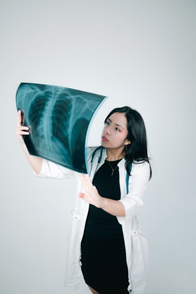 Healthcare professional examining a chest X-ray indoors, representing the weeks of treatment families plan stay and food budgets around
