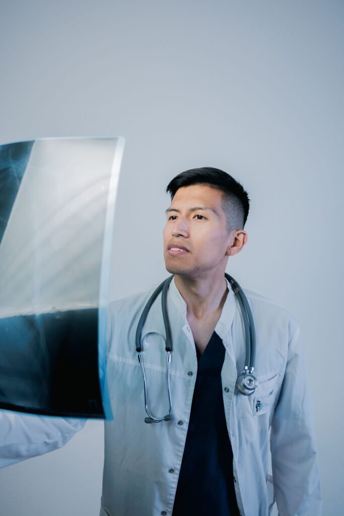 Doctor analysing an X-ray in a medical office, representing the medical details hospitals send to insurers for cashless approval