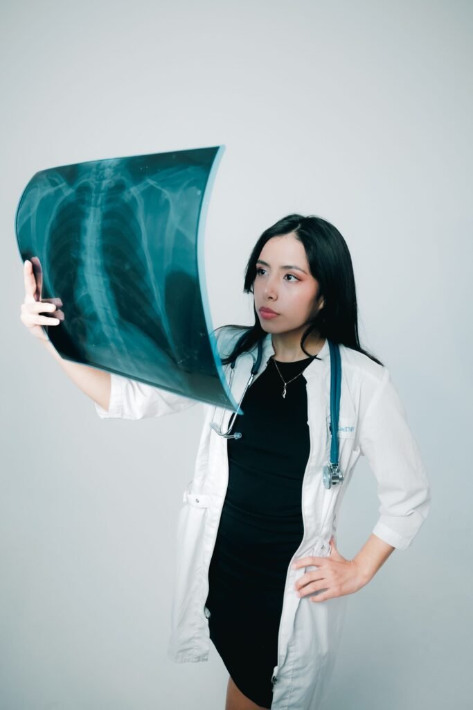 Young female doctor examining a chest X-ray, representing free and low-cost treatment options available in some private hospitals