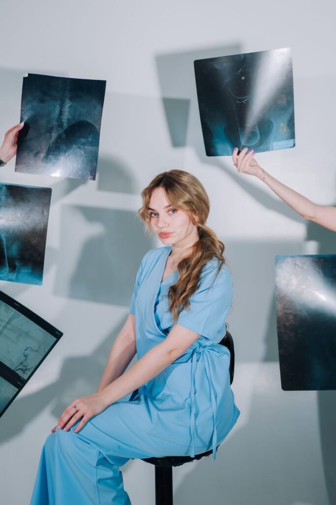 Healthcare worker in blue scrubs reviewing X-ray images, representing treatment at government hospitals