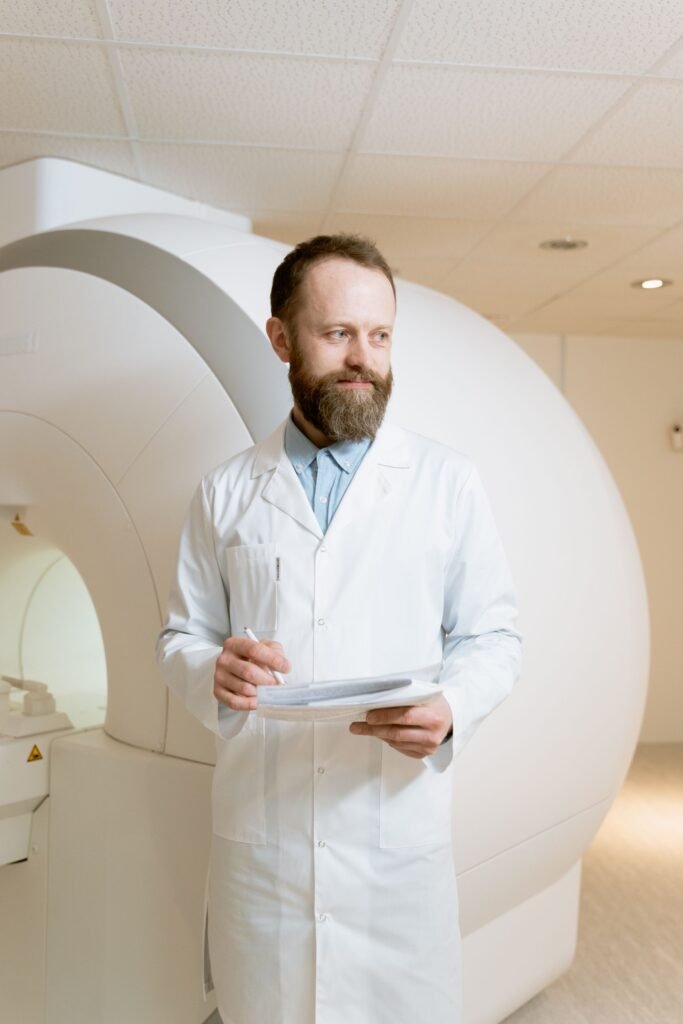 Medical professional standing beside an MRI machine, representing diagnostic charges that insurers should not cut under room rent rules
