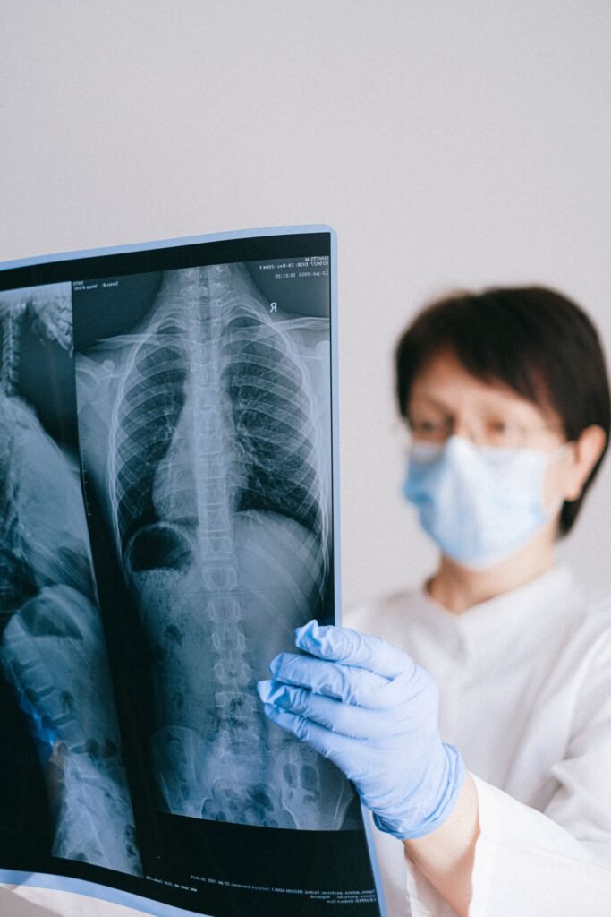 Doctor in a mask examining an X-ray, representing the medical records needed to answer an insurer query on a claim