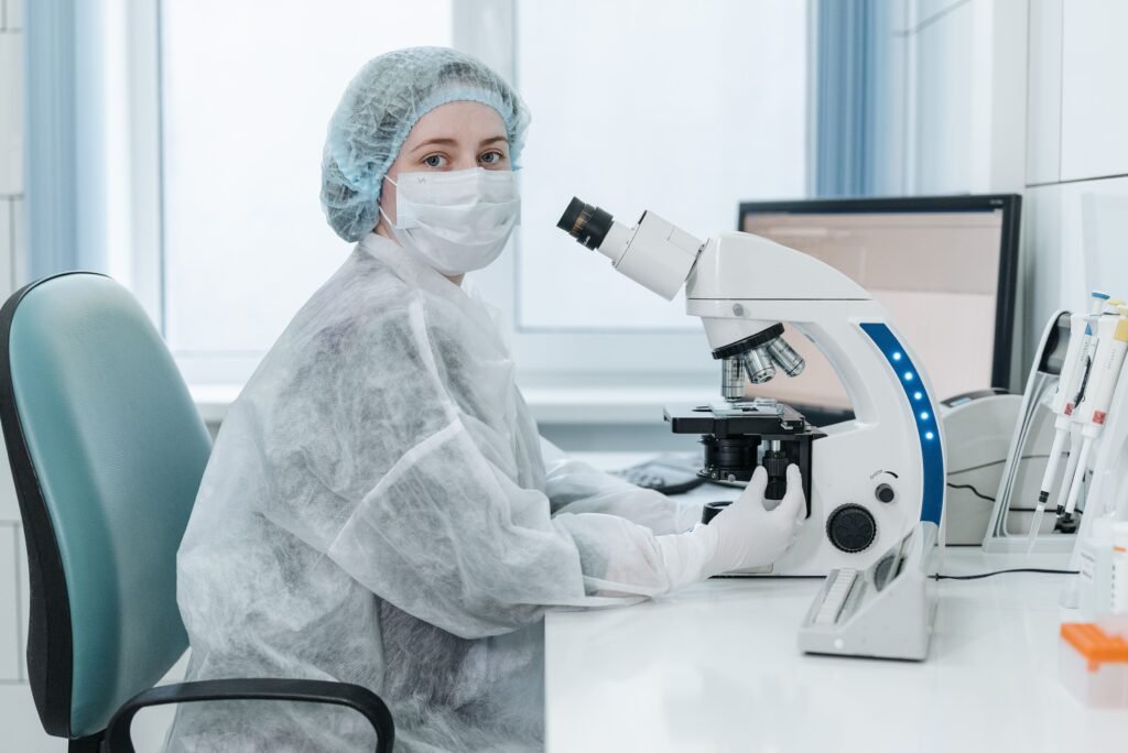 Lab technician examining samples with a microscope