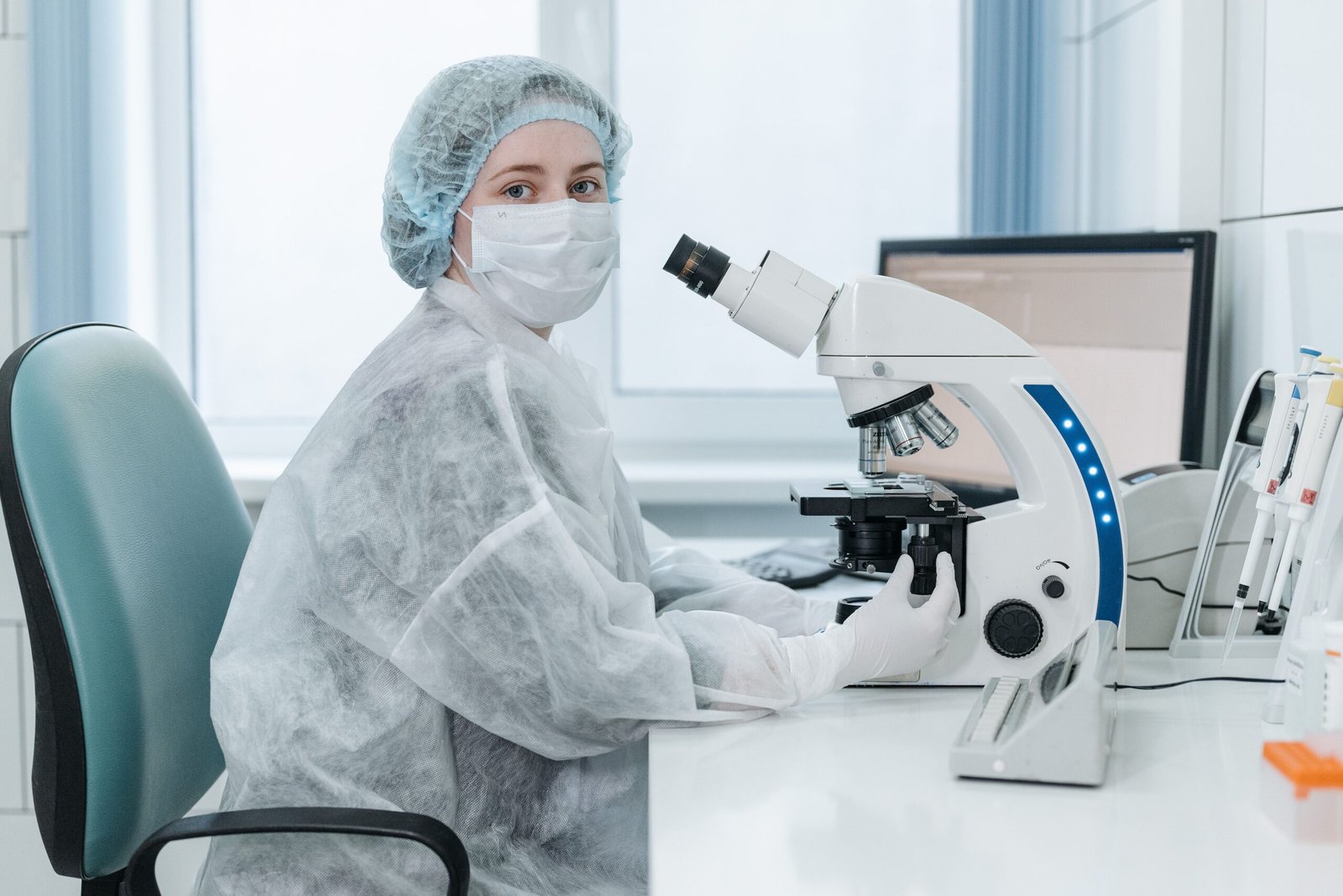 Lab technician examining samples with a microscope
