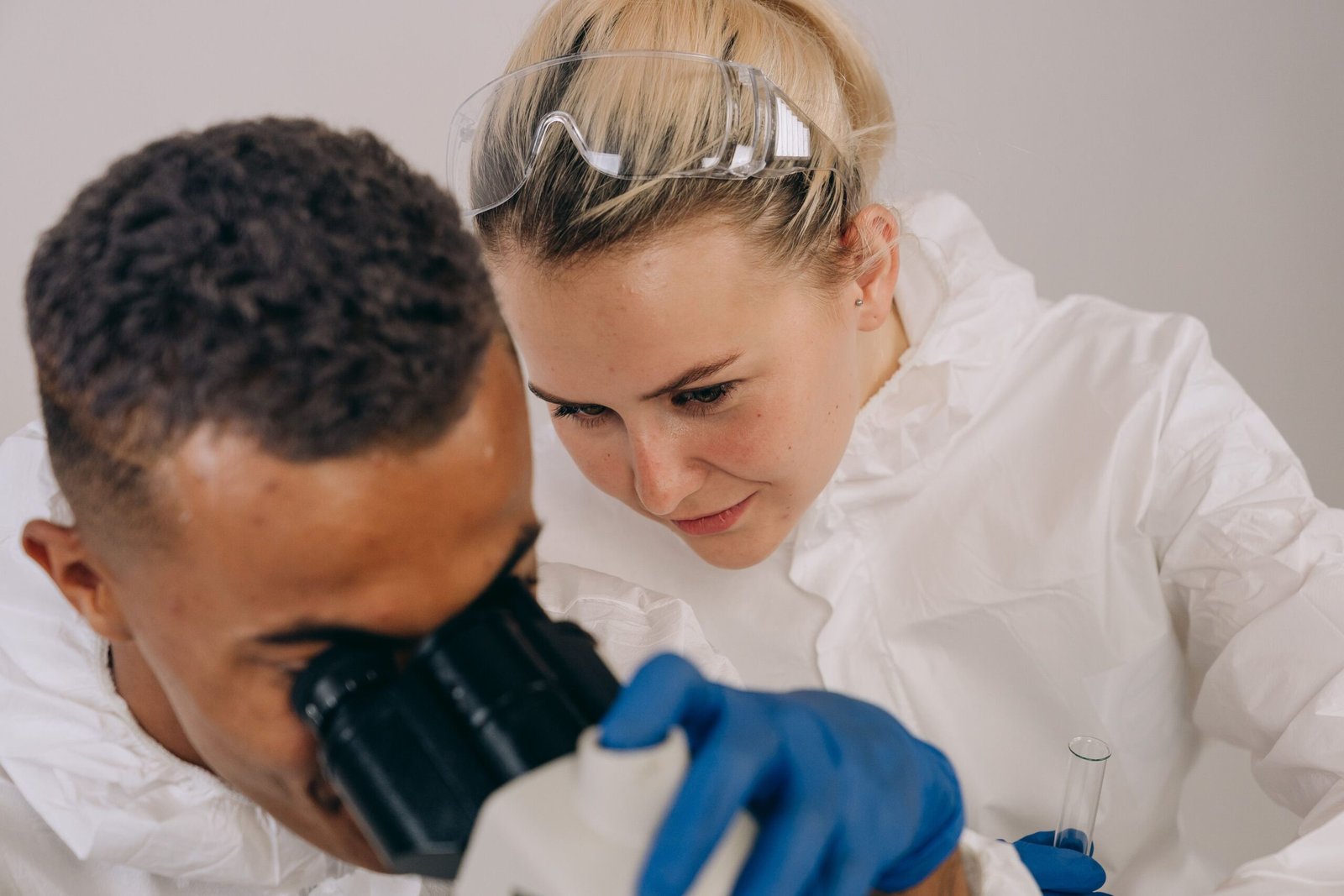 Scientists in lab gear engaged in microscopic research