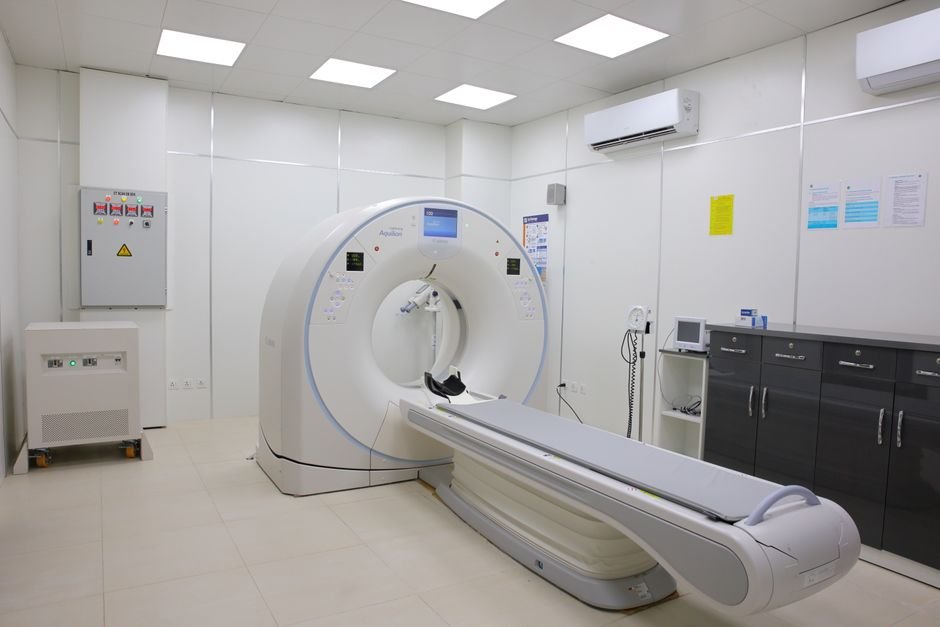 Bright, sterile hospital imaging room with a state-of-the-art CT scanner