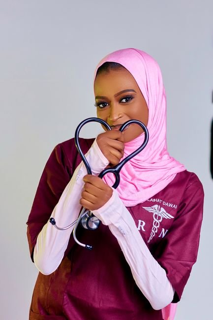 Smiling doctor holding a stethoscope formed into a heart shape