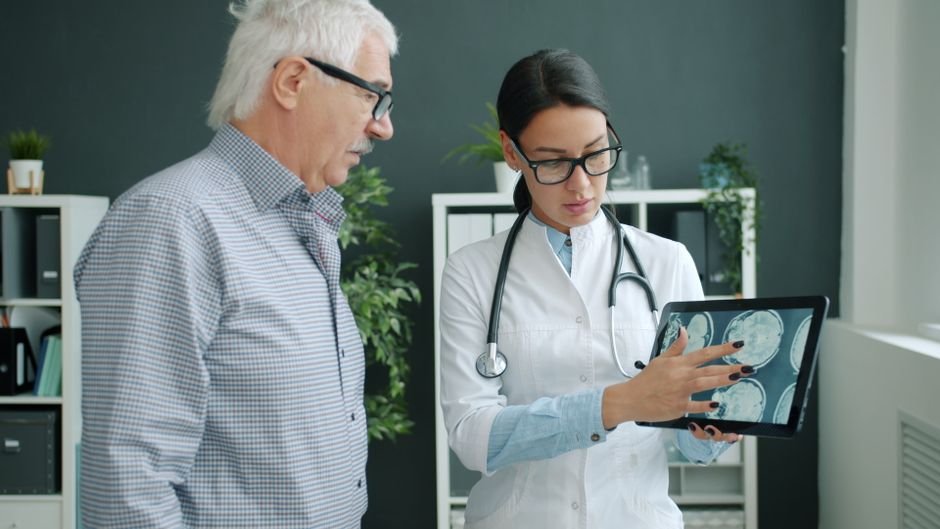 Medical professional reviewing brain scans with a senior patient