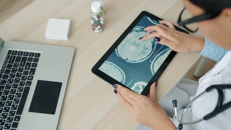 Doctor reviewing scan results on a tablet for a second opinion consultation