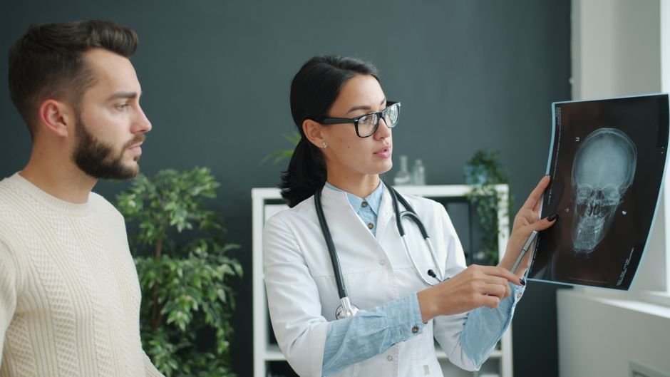 Doctor explaining scan results to a patient in a medical office