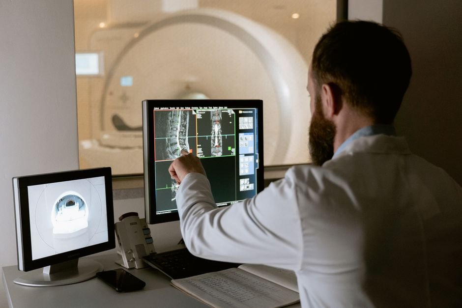 Medical professional reviewing MRI scans on computer screens